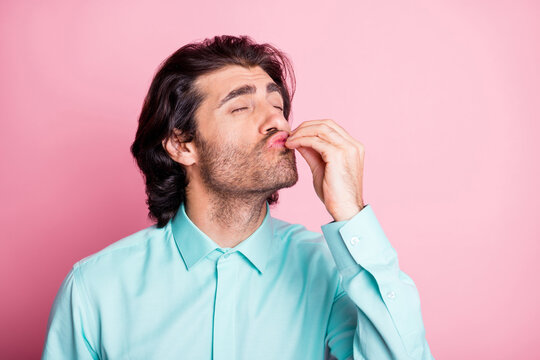 Photo portrait of guy giving chef's kiss isolated on pastel pink colored background