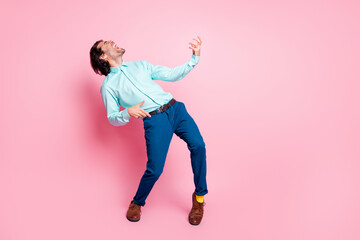 Photo portrait full body view of man playing on air guitar isolated on pastel pink colored...