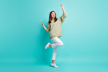 Full length photo portrait of carefree woman standing on one leg dancing reaching hands to the sky...
