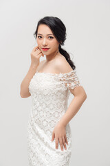 Fototapeta na wymiar Attractive young Asian lady wearing white skinny dress isolated over white background.