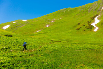 Beautiful mountain landscape with tourists hiking at Caucasus mountains.