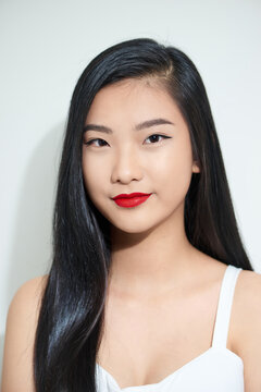 Closeup portrait of a young beautiful attractive asian woman feeling happily over a white background