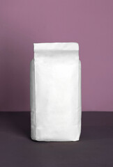 Small blank bulky white package with product on a purple-lilac background . Ready for shipping, delivery and sale. Small business artisan concept.