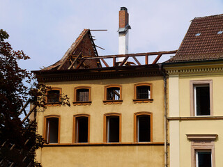 An ancient building with a destroyed roof. Reconstruction of the roof and windows in an old house. - 395700811