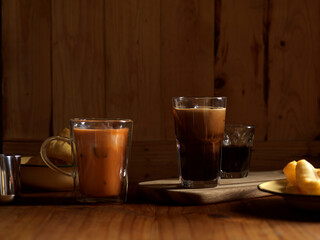 Thai style breakfast with ice coffee, Thai milk tae and deep fried dough stick on wooden table