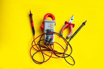 Electrician tools on a yellow background. Multimeter and passages close-up, selective focus