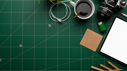 Workspace with tablet, camera, stationery, coffee cup and copy space on cutting board