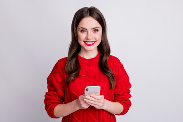 Photo portrait of pretty female blogger holding mobile phone reading information isolated on pastel grey color background