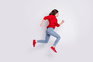 Full length body size photo of jumping high running fast on sale girl in jeans red sweater isolated on grey pastel color background