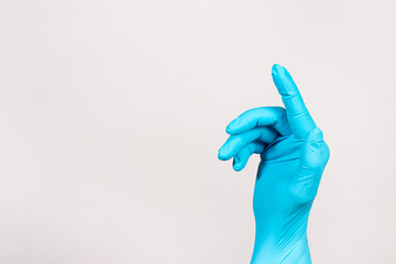 The hand of a proctologist in a glove on a white background. Rectal finger examination for hemorrhoids and diseases of the anus and rectum. Banner with a place for text