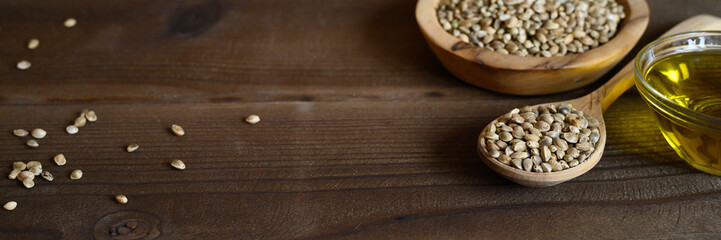 organic dried hemp food seeds in a composition with kitchen objects on a wooden background. banner