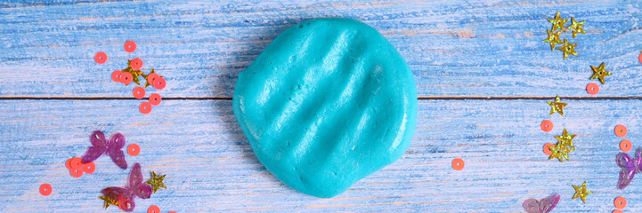 blue slime clod on blue wooden background. banner