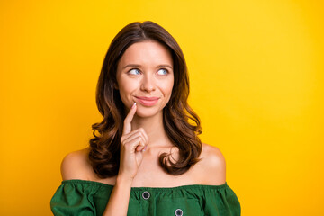 Photo of minded positive young lady look empty space dream inspiration hold finger chin isolated on yellow color background