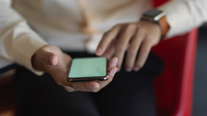 Businessman hands using smartphone while relaxed sitting in office room