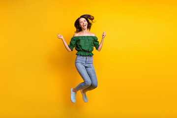 Fototapeta na wymiar Full size photo of attractive happy young woman jump up raise fists lucky discount isolated on yellow color background