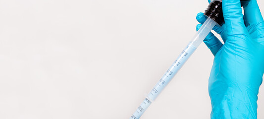 The doctor picks up from the bottle a sprinkle of cough and temperature for children in a measuring...