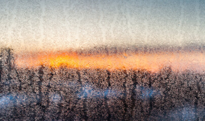 Sunset through frosty pattern on glass