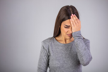 Woman suffering from strong eye pain against a gray background. Female has a pain in the eye....