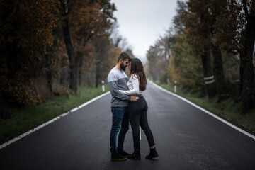 Beautiful portrait of young couple hugging, looking to each other and standing on a perfect clean...