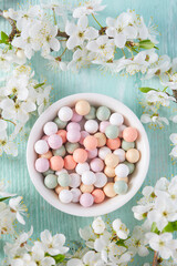 pearl make up powder with with spring tree blossoms on turquoise surface