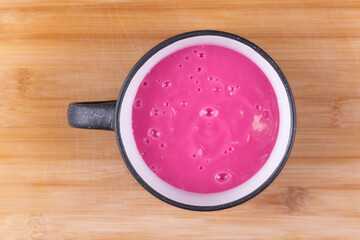 Hot raspberry pudding in a cup on wooden background