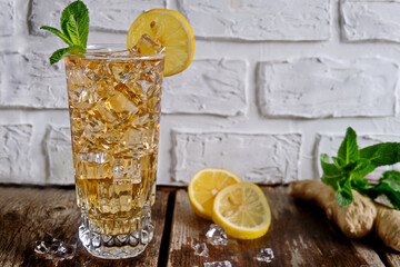 Kombucha tea in a glass. Super food pro biotic beverage in glasses with mint and lemon on wooden background - homemade healthy organic fermented probiotic drink