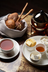 Hotel breakfast set on table with honey, tea, bread