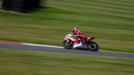 A panning shot of a racing bike cornering on a track.