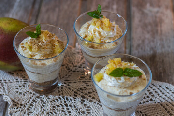 Mango mousse in glass cup with mint on wooden background