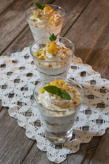 Mango mousse in glass cup with mint on wooden background