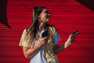 Online shopping - Women with cell phone, credit card and headset in town.