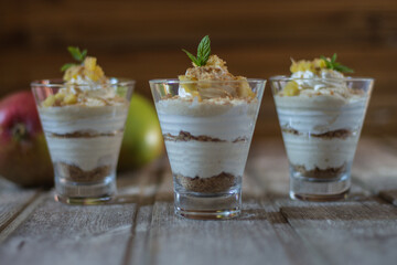 Mango mousse in glass cup with mint on wooden background