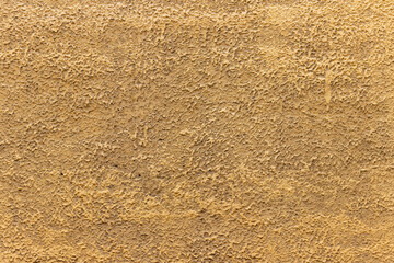 The surface of the wall, plastered in light brown.