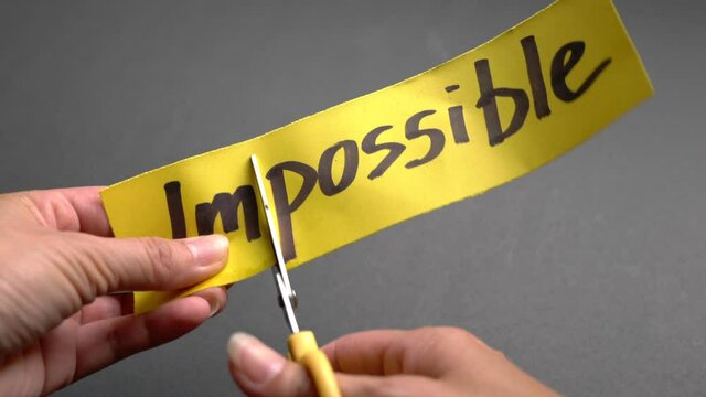 Woman cut paper with Impossible to Possible. Positive thinking or self-belief concept.
