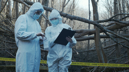 Detectives are collecting evidence in a crime scene. Forensic specialists are making expertise....