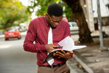 young businessman checking his notes in his register