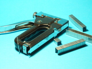 Furniture stapler on a blue background. Tools and accessories.