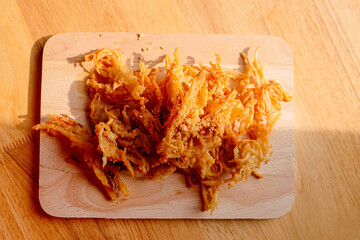 Fried Enoki Mushroom or Golden Needle Mushroom on wood table.