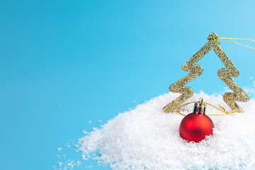Red Christmas Balls and christmas tree In Snow on a blue background