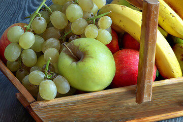 Raisin, pomme Golden, bicolores et banane dans un panier de vendanges