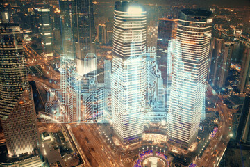 Double exposure of buildings hologram over cityscape background. Concept of smart city.
