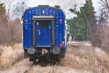 Steam train moves at autumn day time.