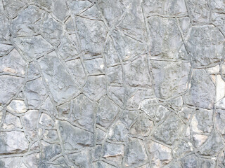Background gray textured wall with rough stone patterned masonry