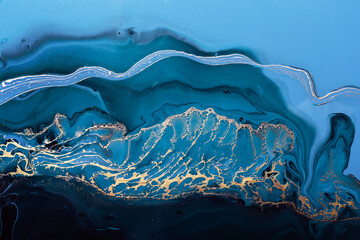 Acryl vloeistof kunst. Gouden golf in abstracte oceaan van blauwe verf en gouden poederdeeltjes. Achtergrond of textuur met marmereffect