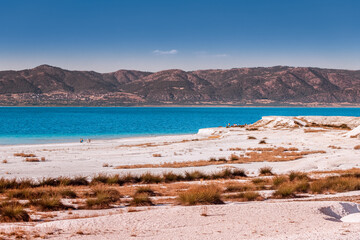People resting and relaxing on the shore of popular tourist destination in Turkey - Salda Lake