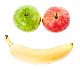 Two apples and a banana forming a happy face. Studio photo isolated on white background. Selective focus on object.