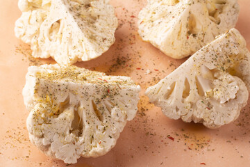 cauliflower with spices and herbs on baking paper.