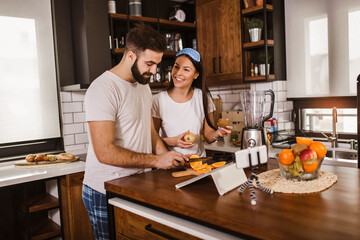 Couple making fresh organic juice in kitchen together