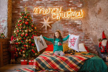 little girl Asian girl in her pajamas in the bedroom messing around on the cushions, Christmas, new...