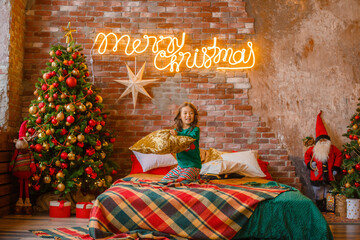 little girl Asian girl in her pajamas in the bedroom messing around on the cushions, Christmas, new...
